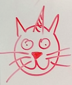 A drawing of a unicorn cat face in red marker on white board.